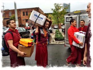 Tibetan monks unload mandala supplies.