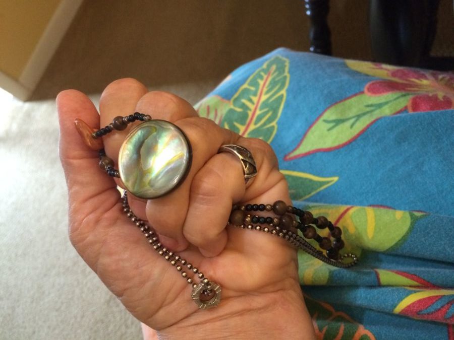 I love the connections between inanimate objects and those people or events that are most important to us. Some of those connections are apparent, while others are revealed in time. I don’t wear or even own much jewelry. I’ve never been that interested. However after I read your article about amulets and talismans, I realized there is more to my few favorite pieces than I realized. Almost every day I wear a small charm that my sister gave me which to her looked like and represented a life preserver. She gave my sister who was her bone marrow donor a gold one, I got the silver for being the backup donor. The reminder of our bond is a comfort to me. Almost forty years ago my Dad brought me a gift from Hawaii. It is a handmade beaded necklace featuring a beautiful round piece of abalone. It has always been my go to dress-up necklace even though it’s not fancy or bejeweled. Inspired by your “Carol talisman” I researched the healing properties of abalone. It’s no wonder I feel a connection to it…I found out it has calming and soothing properties as well as healing for arthritis and heart issues -and an even more meaningful connection with my Dad.