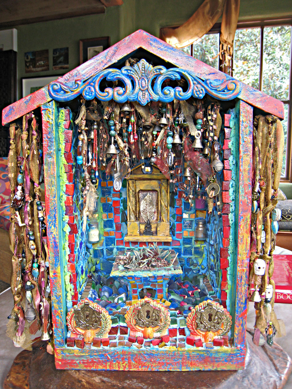 Ornate wooden reliquary shrine with hanging elements and mosaic tiles