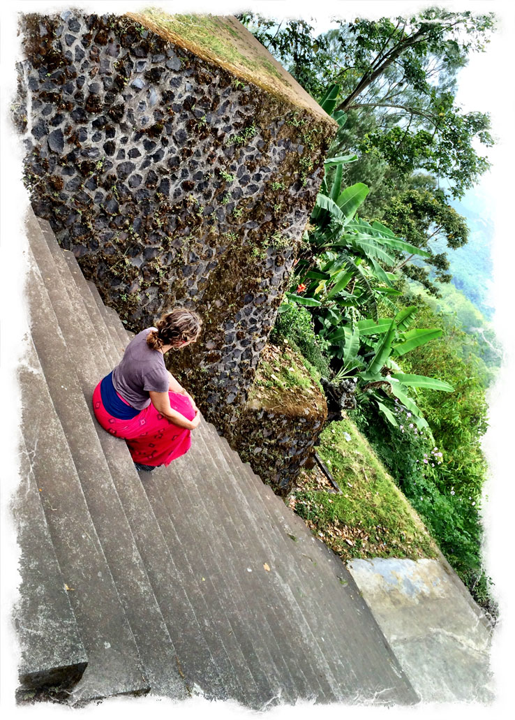 Person in purple top with red inflatable tube on concrete embankment